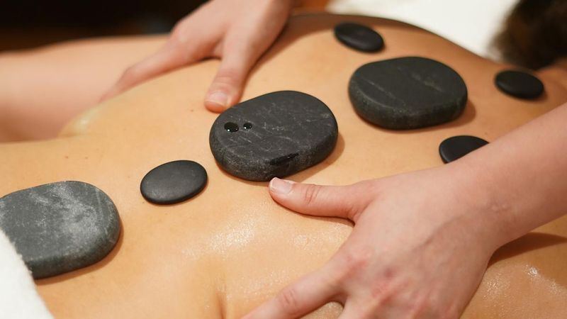 The Complete Guide to Hot Stone Massage Benefits and Techniques - Meraki Spa Raipur