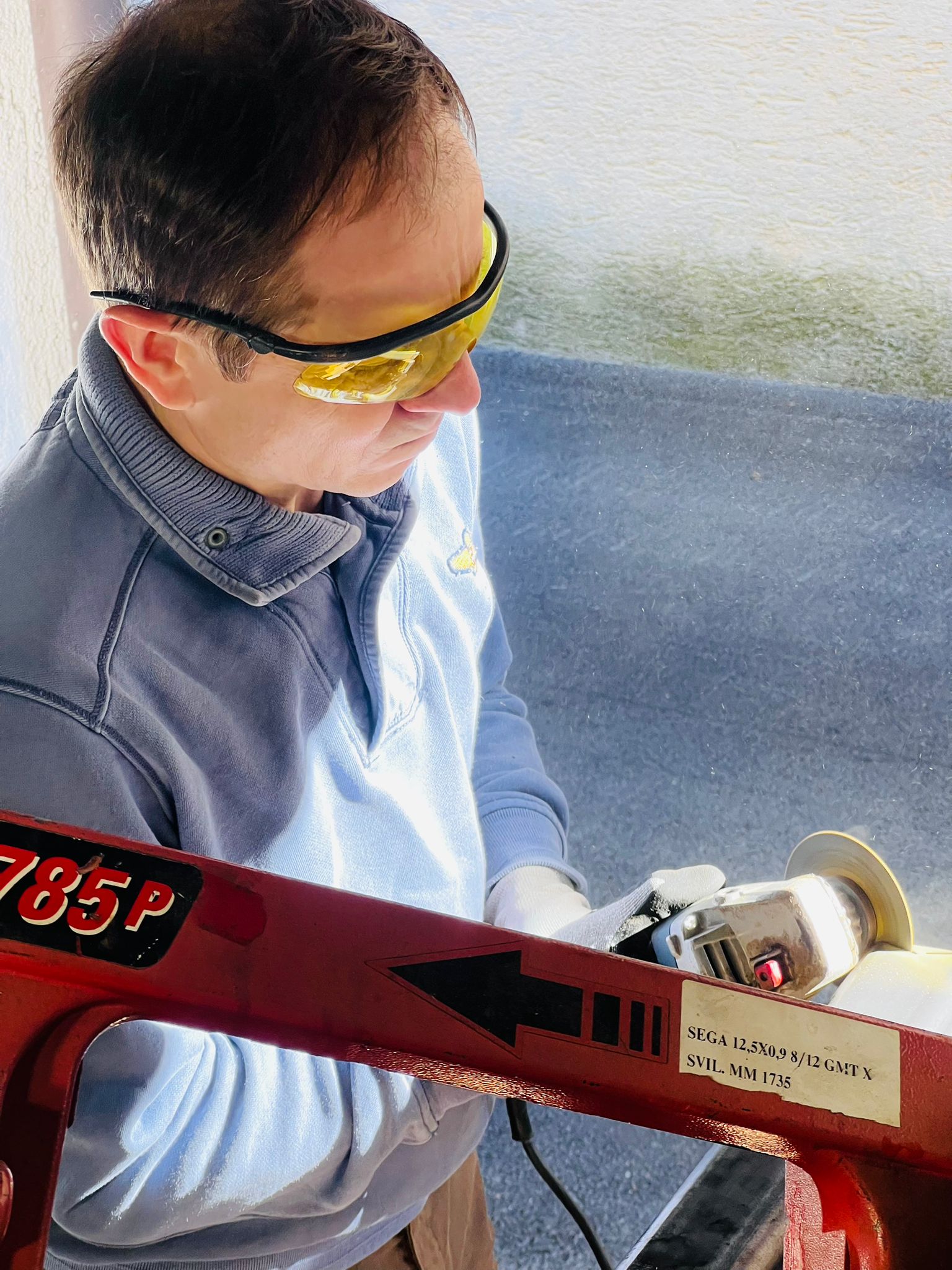 Vitalii Borys cutting a steel tube in the workshop