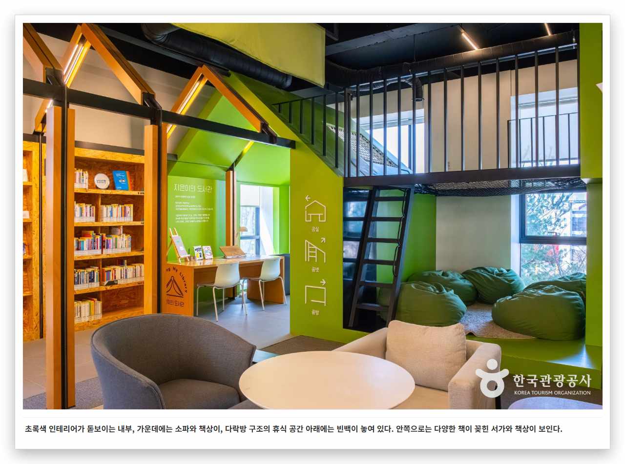 초록색 인테리어가 돋보이는 내부, 가운데에는 소파와 책상이, 다락방 구조의 휴식 공간 아래에는 빈백이 놓여 있다. 안쪽으로는 다양한 책이 꽂힌 서가와 책상이 보인다.