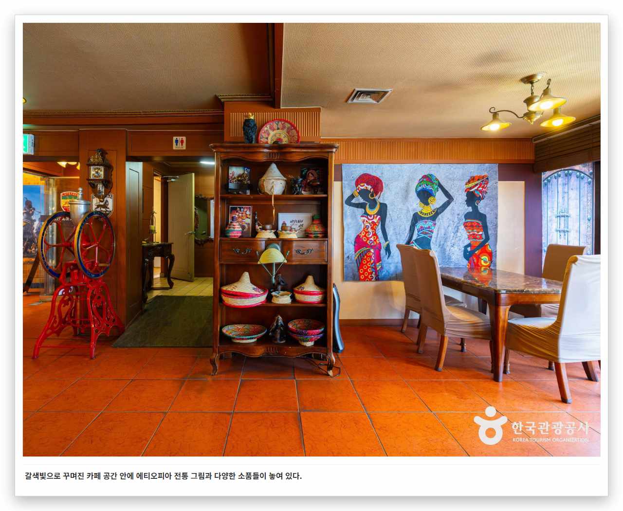 갈색빛으로 꾸며진 카페 공간 안에 에티오피아 전통 그림과 다양한 소품들이 놓여 있다. 