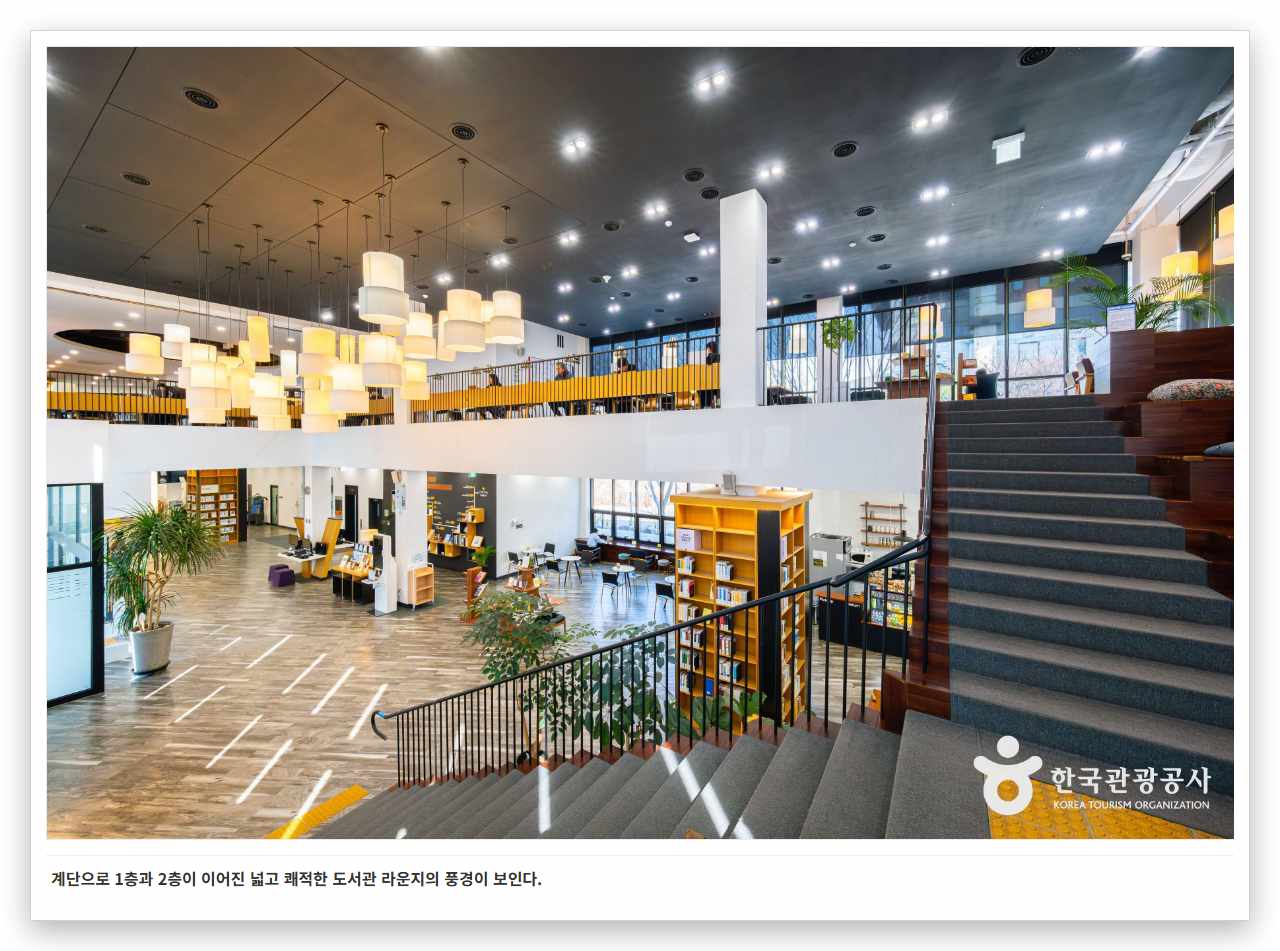 계단으로 1층과 2층이 이어진 넓고 쾌적한 도서관 라운지의 풍경이 보인다.