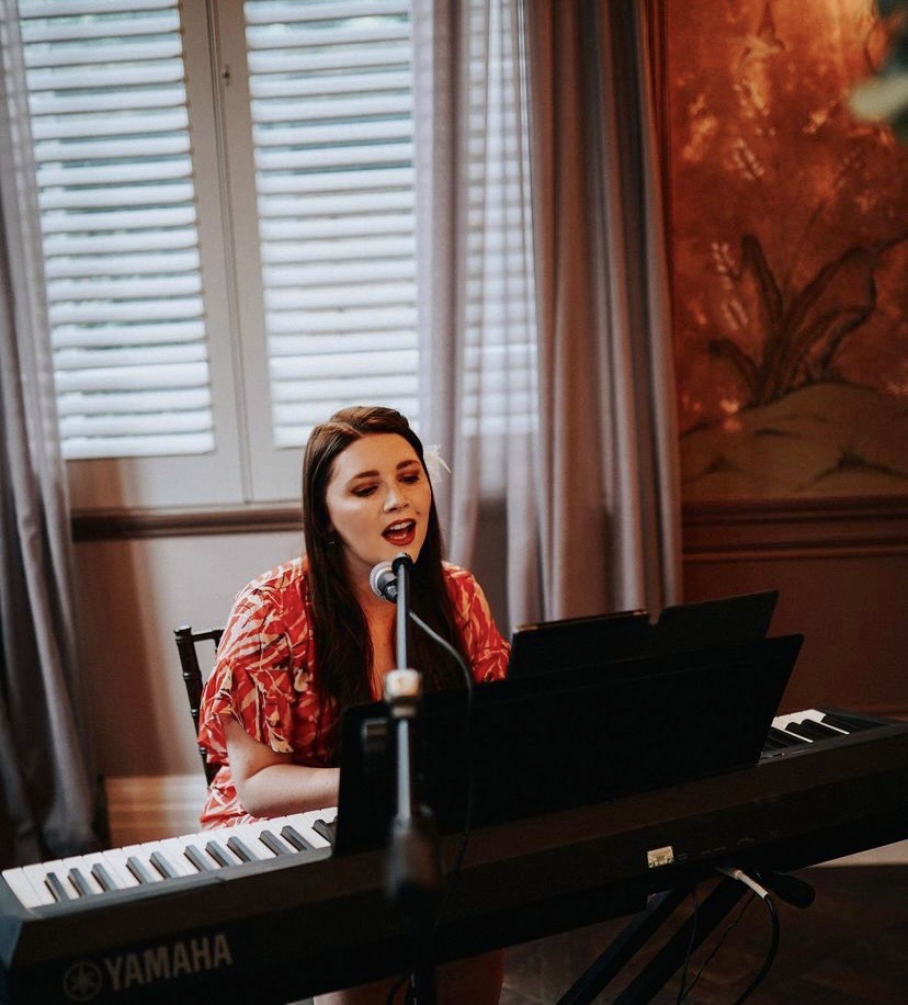 Kasia Howley singing live at a piano