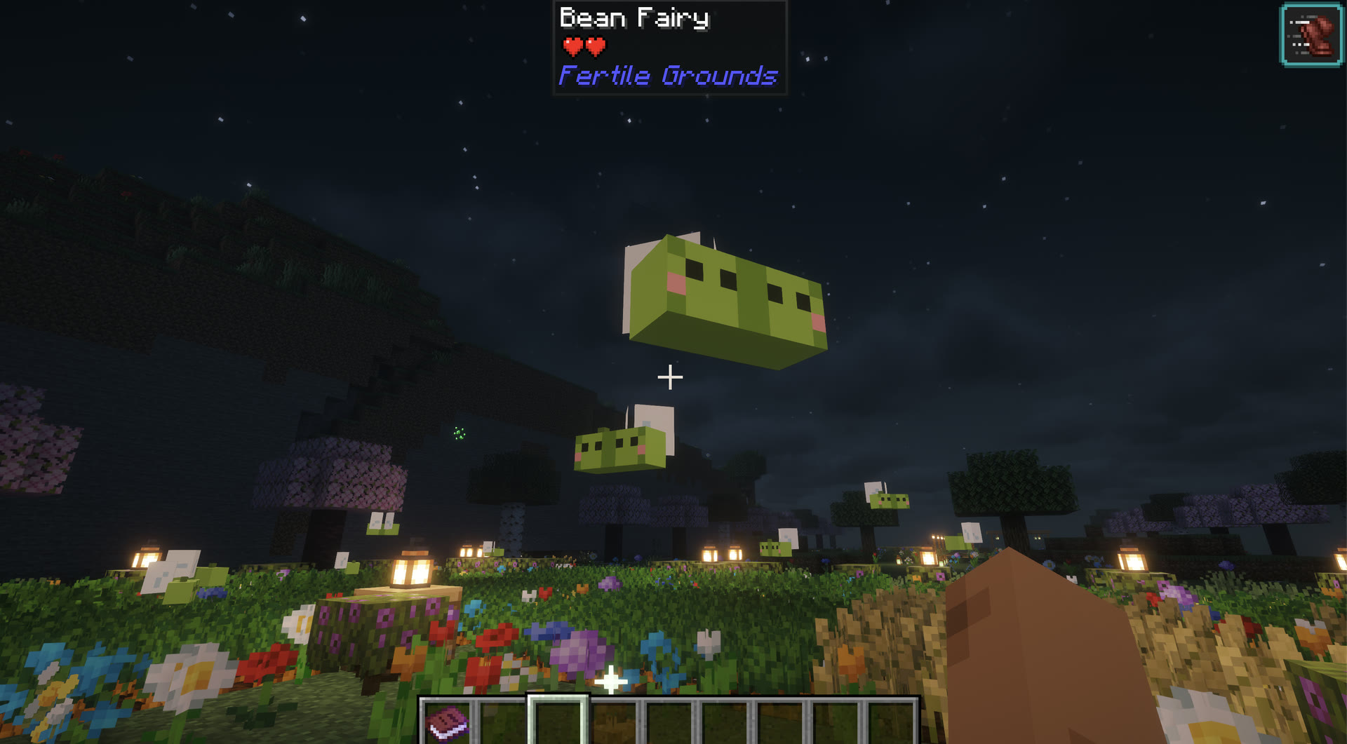 Bean Fairies hovering over a flower-filled Fairy Grove at night, lit by lanterns