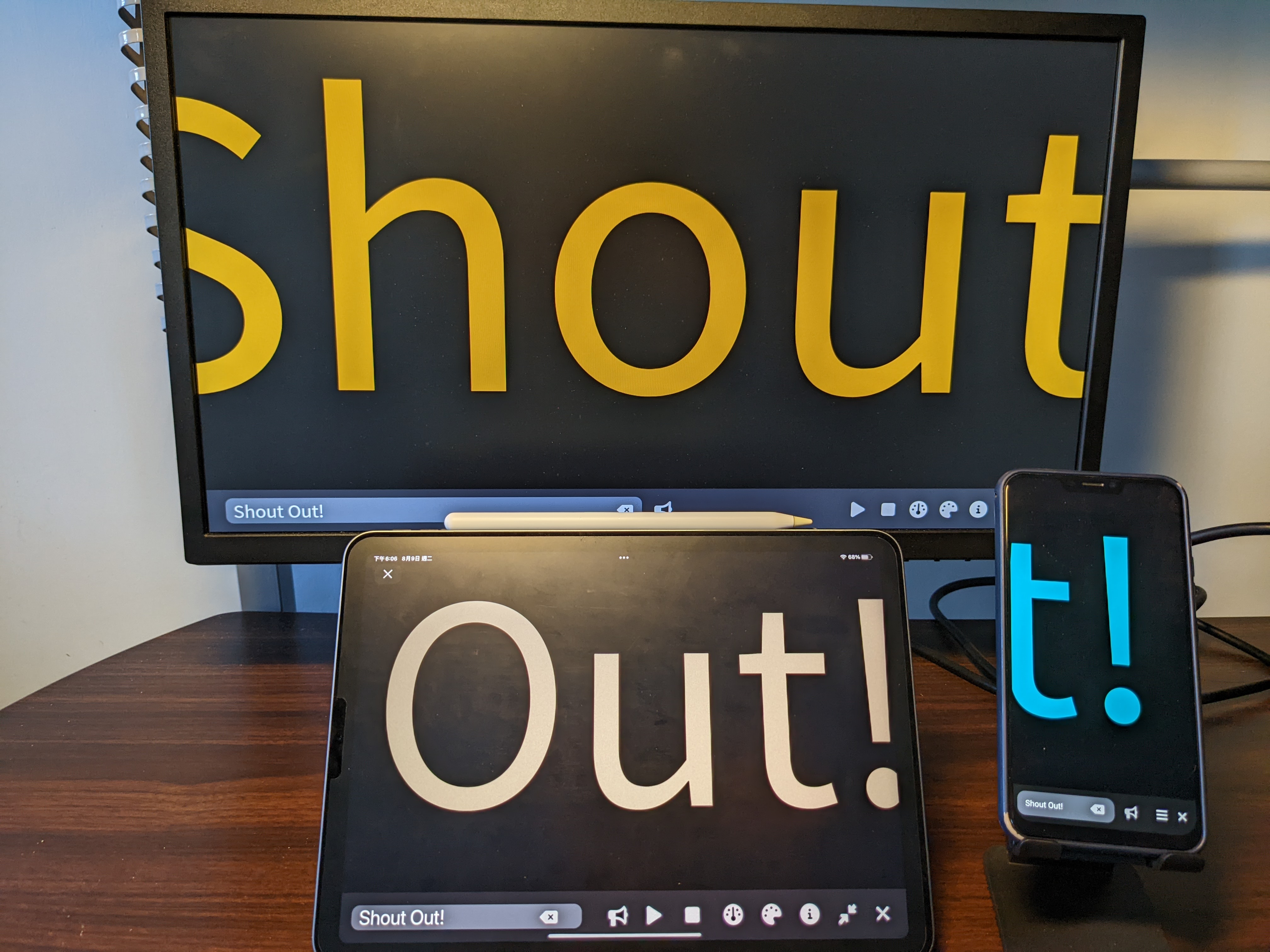 a photo with a screen monitor, a tablet, and a smartphone displaying "Shout Out!" with this app