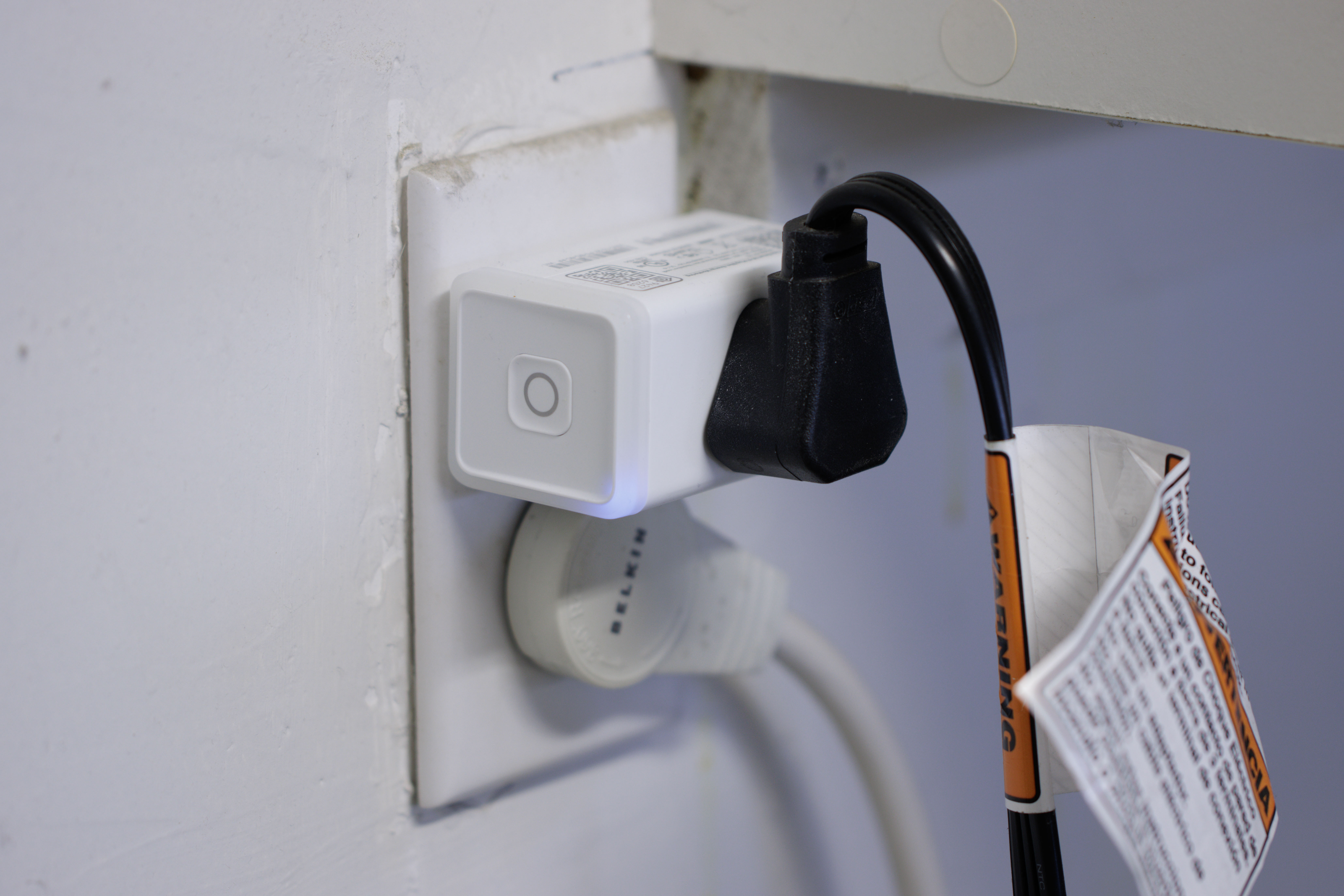 Washing machine power cord plugged into a Kasa KP125 smart outlet, plugged into a 120V wall outlet