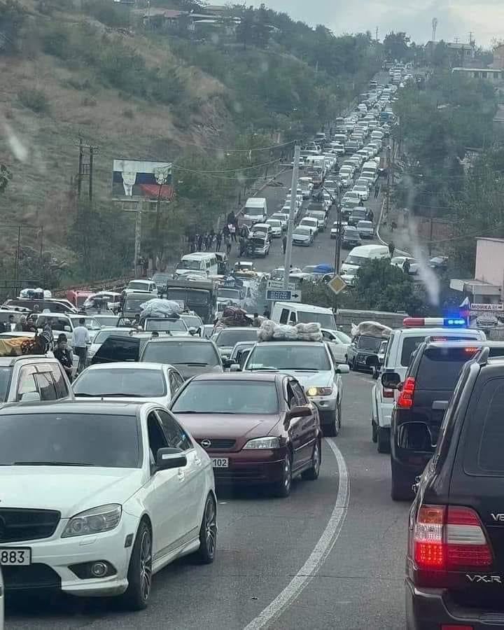 A roadway packed with civilian vehicles for as far as the eye can see.