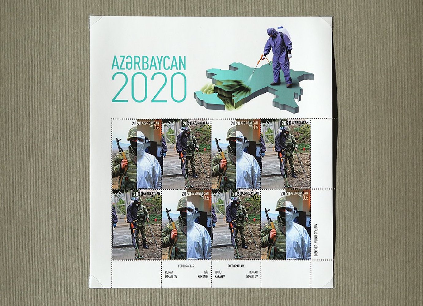 A propaganda poster titled Azerbaijan 2020. A man in a hazmat suit stands atop a 3D map of Azerbaijan and sprays the region of Nagorno-Karabakh to "disinfect" it. Below that are photos divided into two halves with a vertical divider: the left half depicts a man in military uniform, while the right half shows the same man wearing a hazmat suit, implying that Azeri soldiers are disinfecting Armenians by fighting against them.