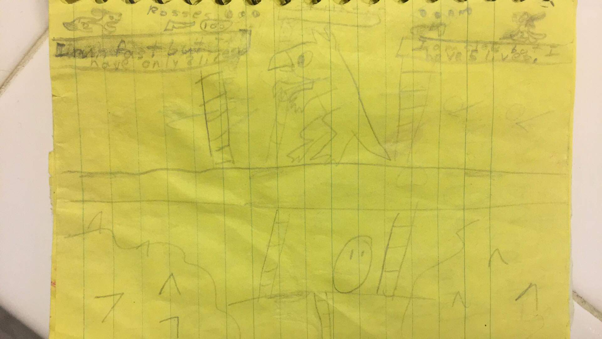 A yellow page in a notebook featuring a child's drawing of a made-up video game.