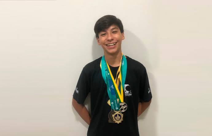 Miguel Pergher sorrindo com as medalhas conquistadas