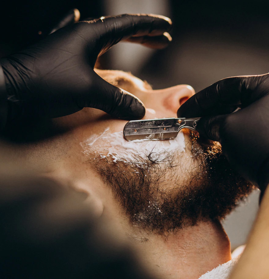 Ein Barber arbeitet an den Konturen eines Bartes