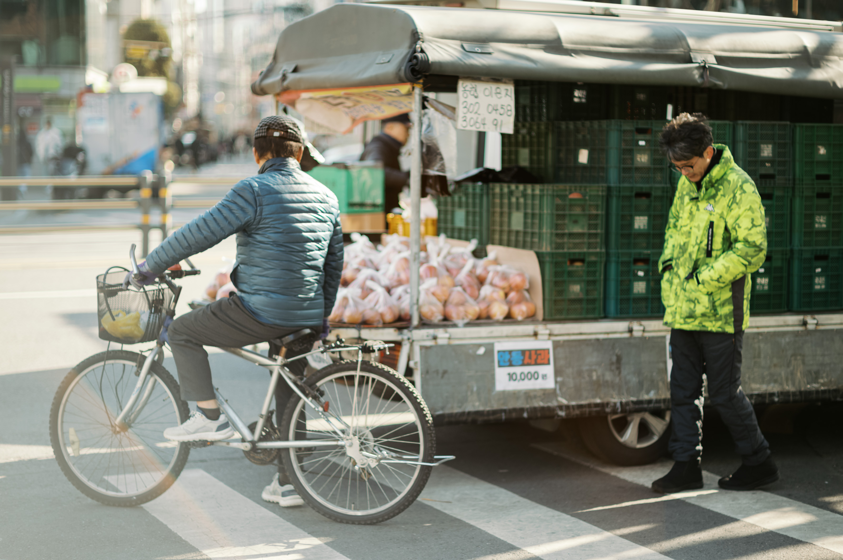 Men on bike looking at vendor stall