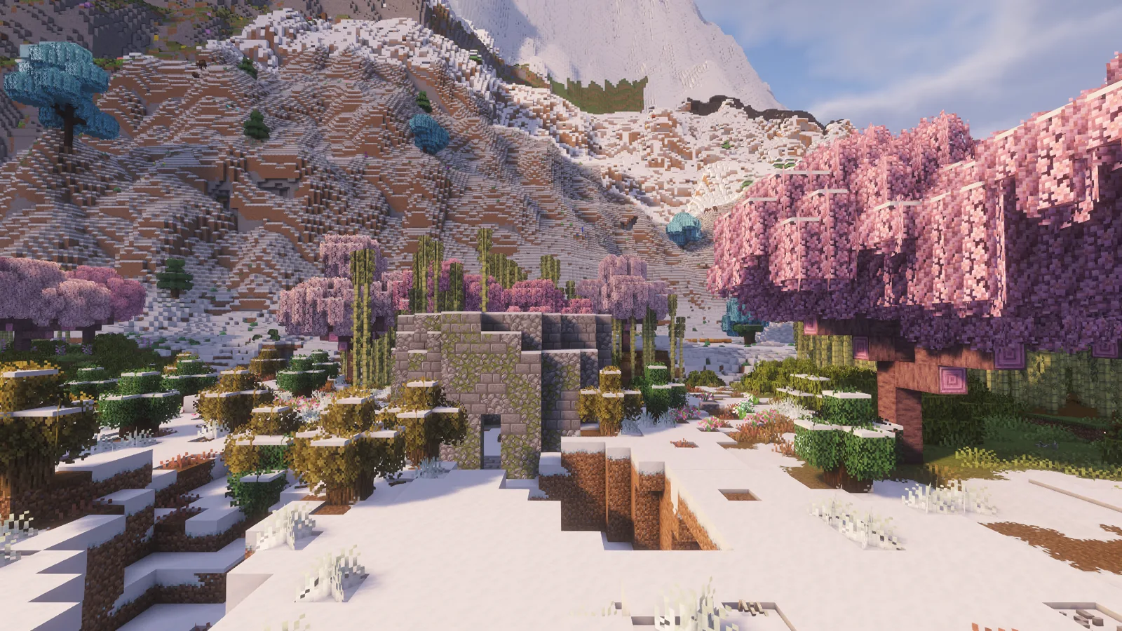A round stone tower in snow below white peaks, blossom around it