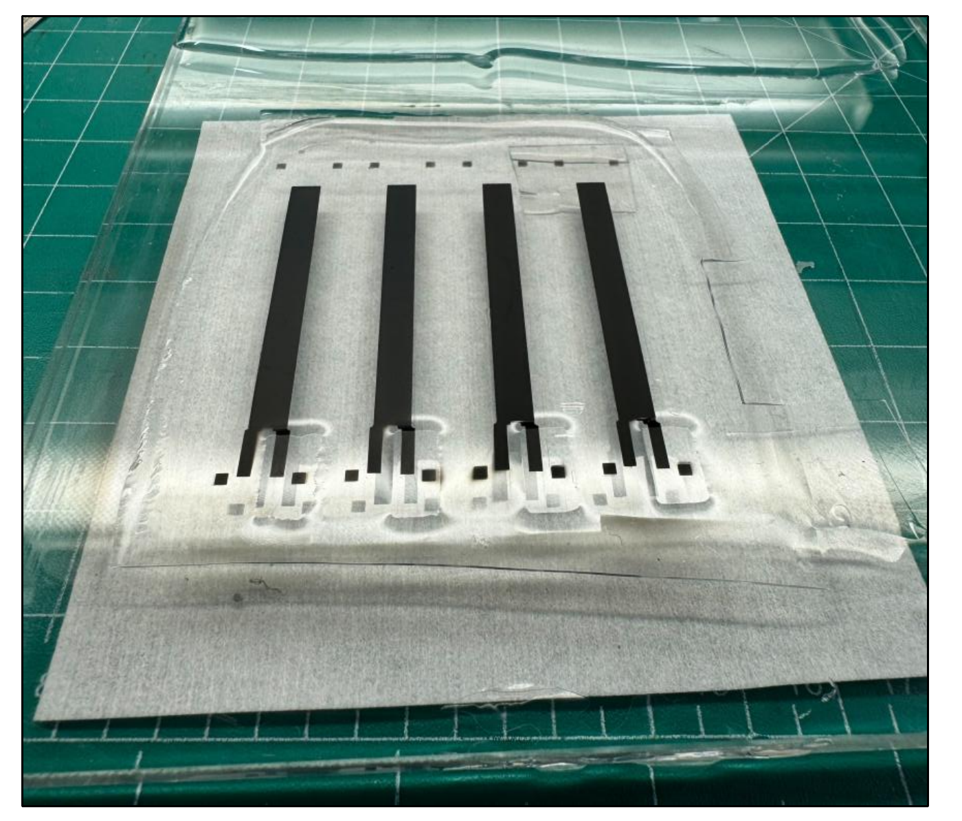 Photo of the sensor strips after the second CNT spray coat, laid out on a cutting mat