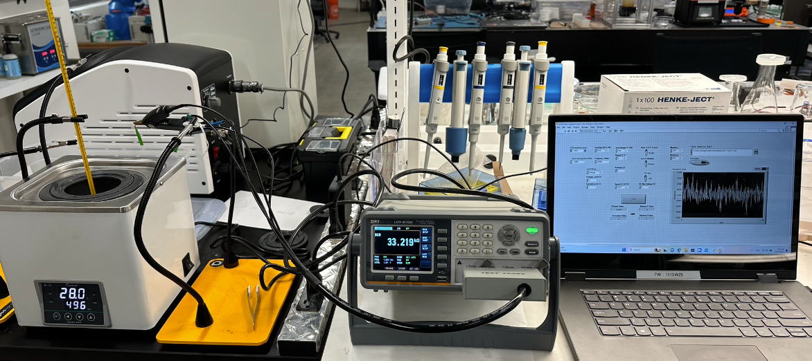 The setup of temperature sensor calibration and characterization: a heated water bath, LCR meter reading resistance, and a laptop logging data
