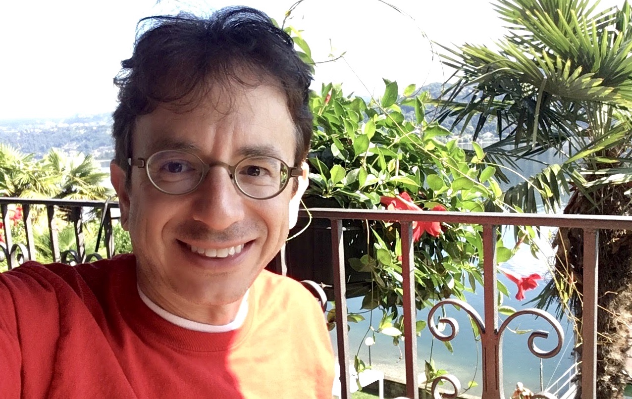 Image of Todd T taking a selfie with a tropical beach in the background.