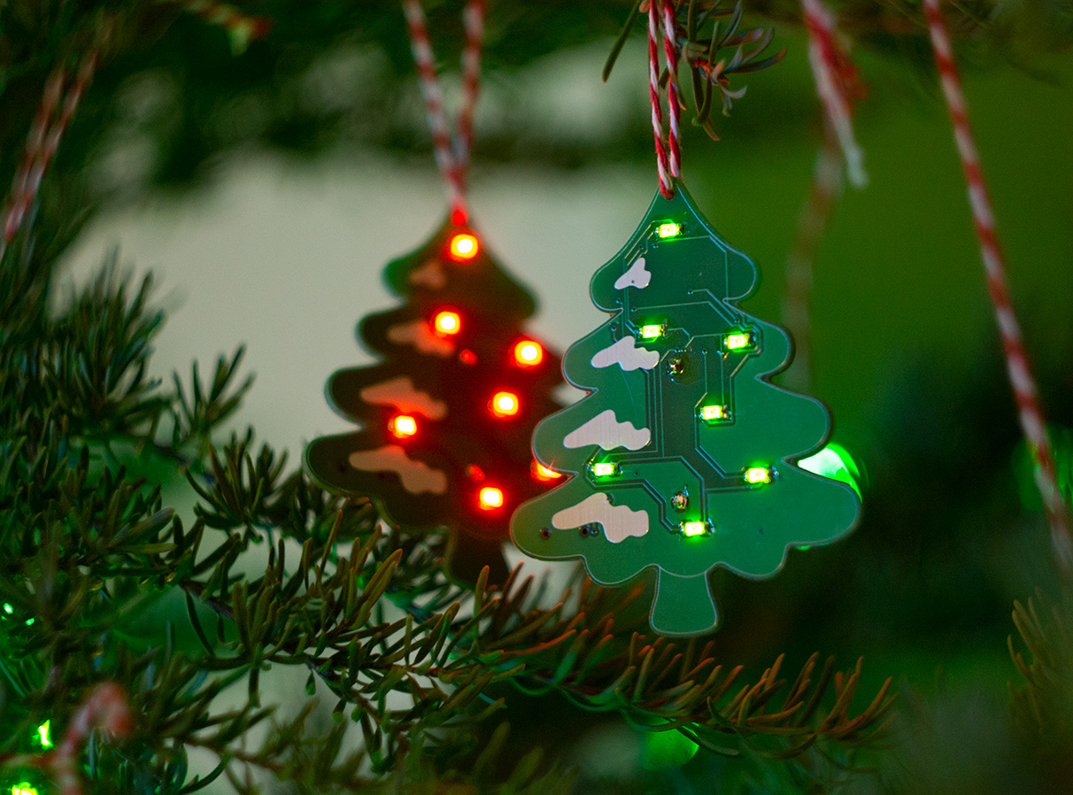 Picture of the ornament on a tree with the lights on.