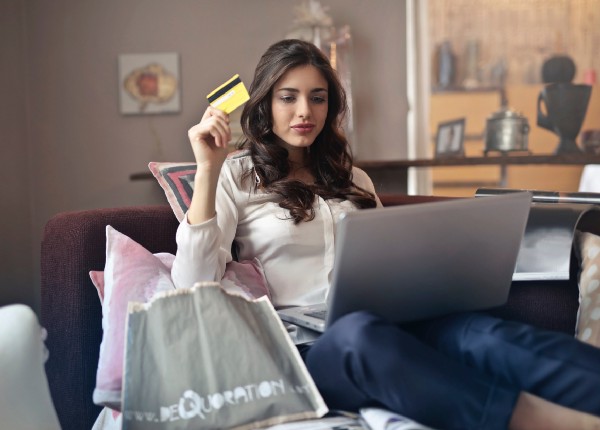 Woman sitting in chair with credit card and laptop