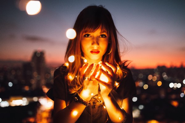woman holding lights in her hands and staring into the camera