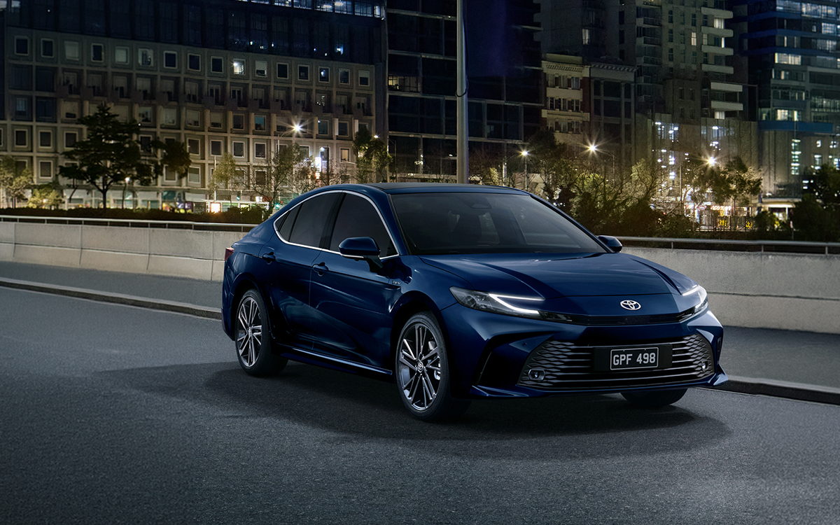 Blue Toyota Camry parked on a city street at night