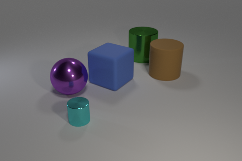 A synthetically rendered image of a small cyan metallic cylinder, a large purple metallic sphere, a large blue matte cube, a large brown matte cylinder and a large green metallic cylinder (from front to back) on an infinite flat matte gray surface.