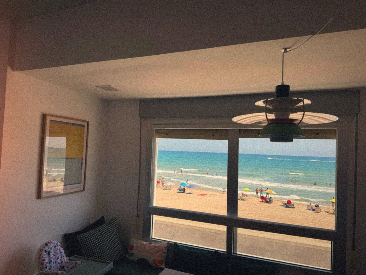La playa de la Llastra con sombrillas de colores, vista desde la ventana del salón del apartamento Valencia Frente al Mar