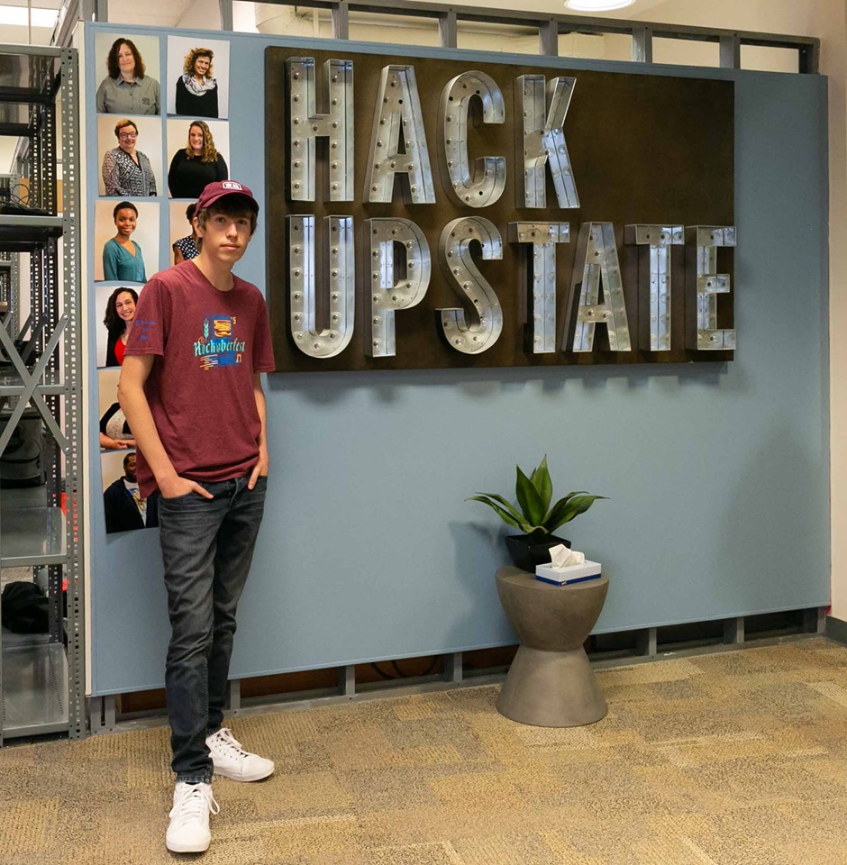 Gavin standing in front of the Hack Upstate sign