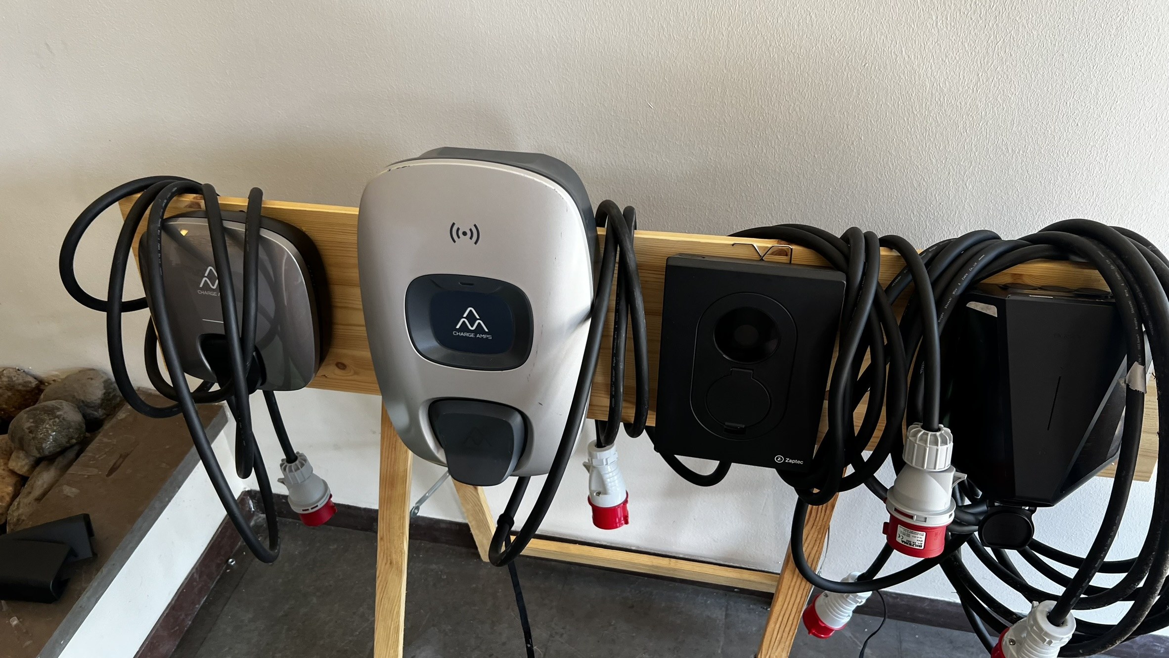 The bench: Charge Amps (left, dark), Charge Amps Aura/Halo (silver, centre), Zaptec (black, right of centre), Easee Charge Up (far right)