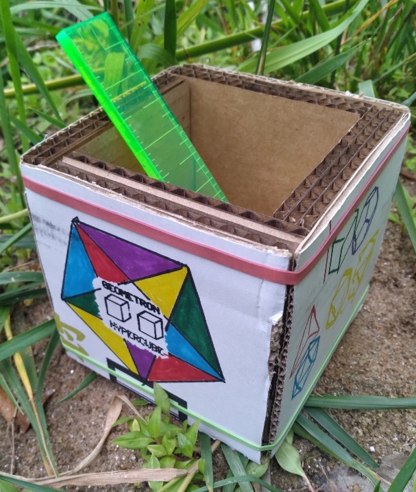 a cardboard cube on grass