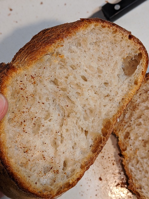 a loaf sliced open. the crumb is light brown and well opened