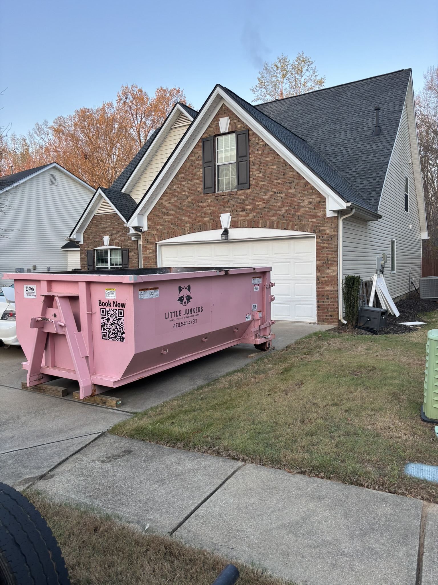 11-yard dumpster with construction wood in driveway