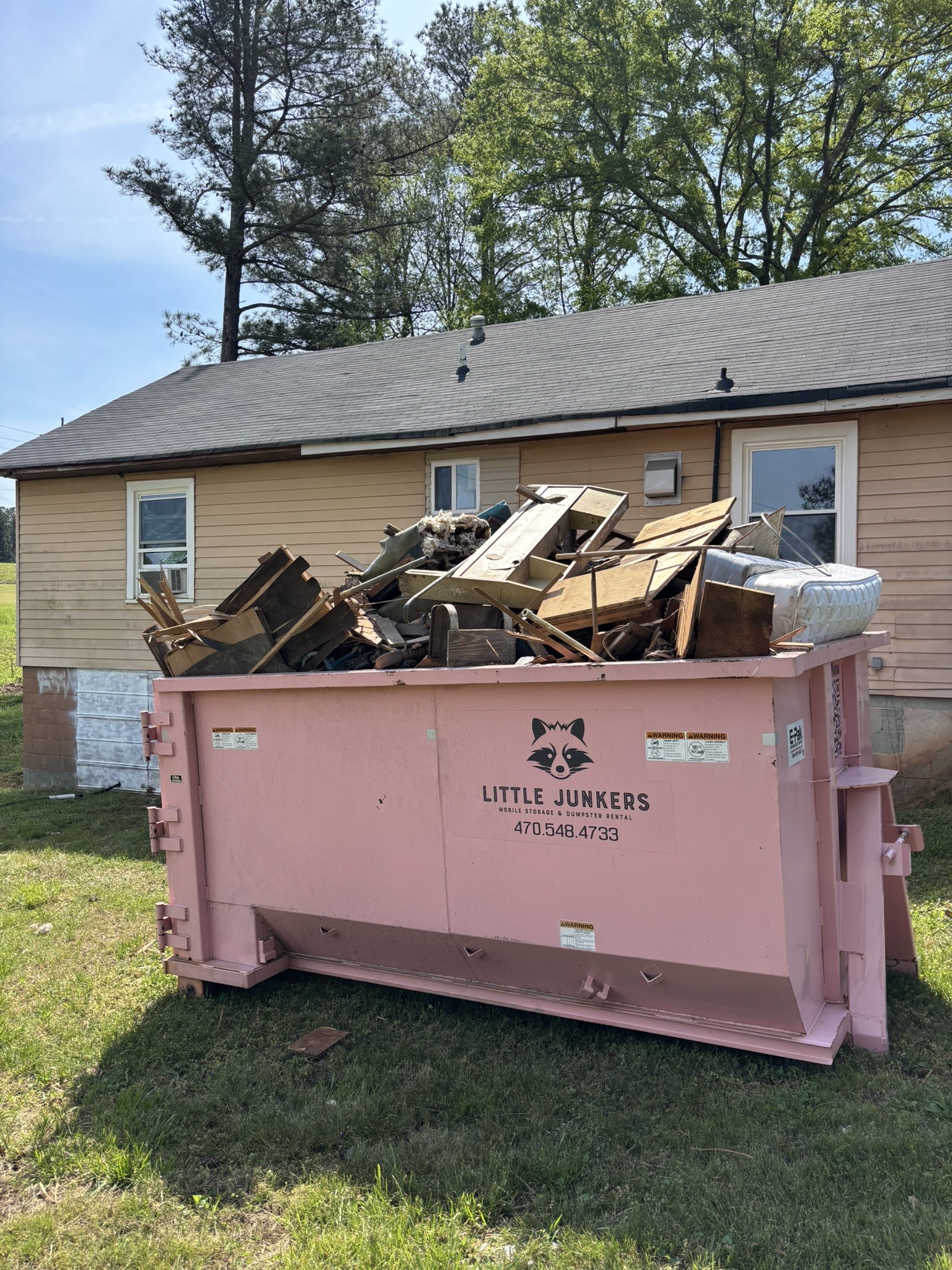 Overloaded Little Junkers dumpster showing why debris should stay below the fill line