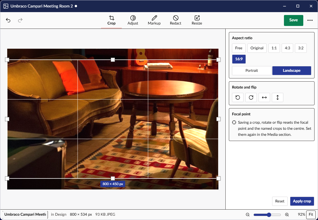 The Image Editor in a window on the desktop, cropping a photo of a lounge to 16:9: the crop frame with its thirds and handles over the picture, the Crop panel with the ratios, rotate and flip, and the note that a crop resets the focal point, and the status bar with the file's name, folder, size and zoom.
