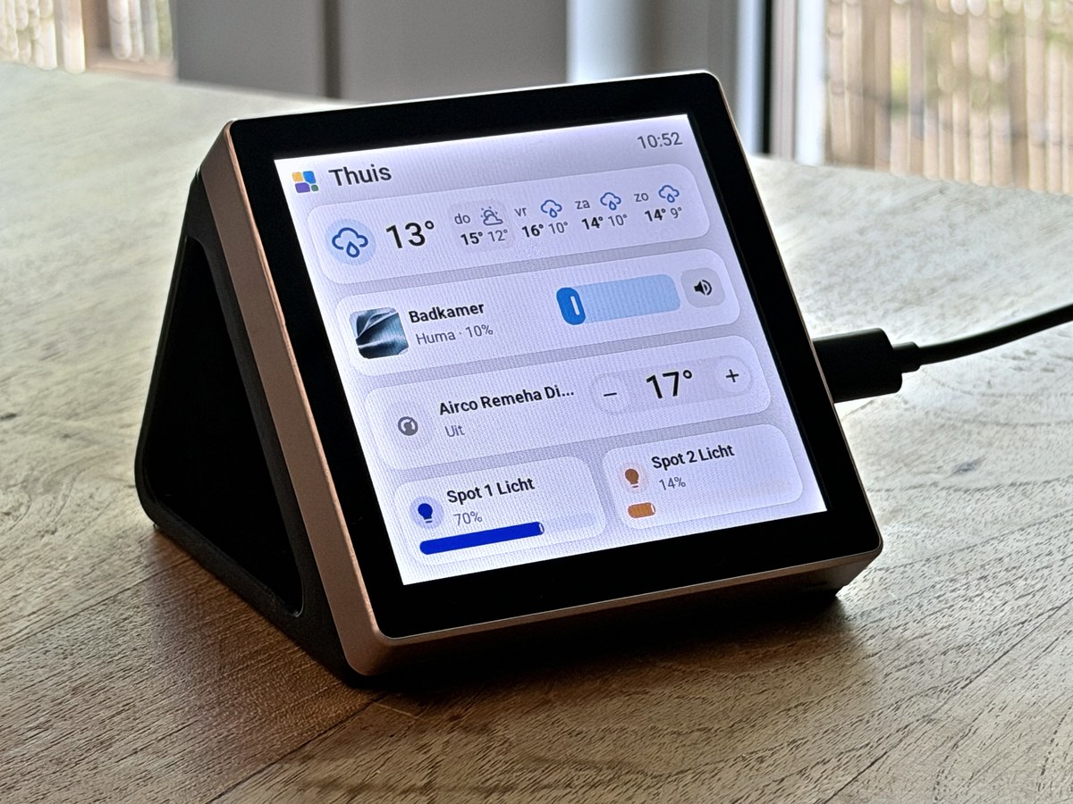 The 4-inch Guition in a black printed wedge stand on a wooden table, showing a home page with the weather, a speaker, the airco and two lights