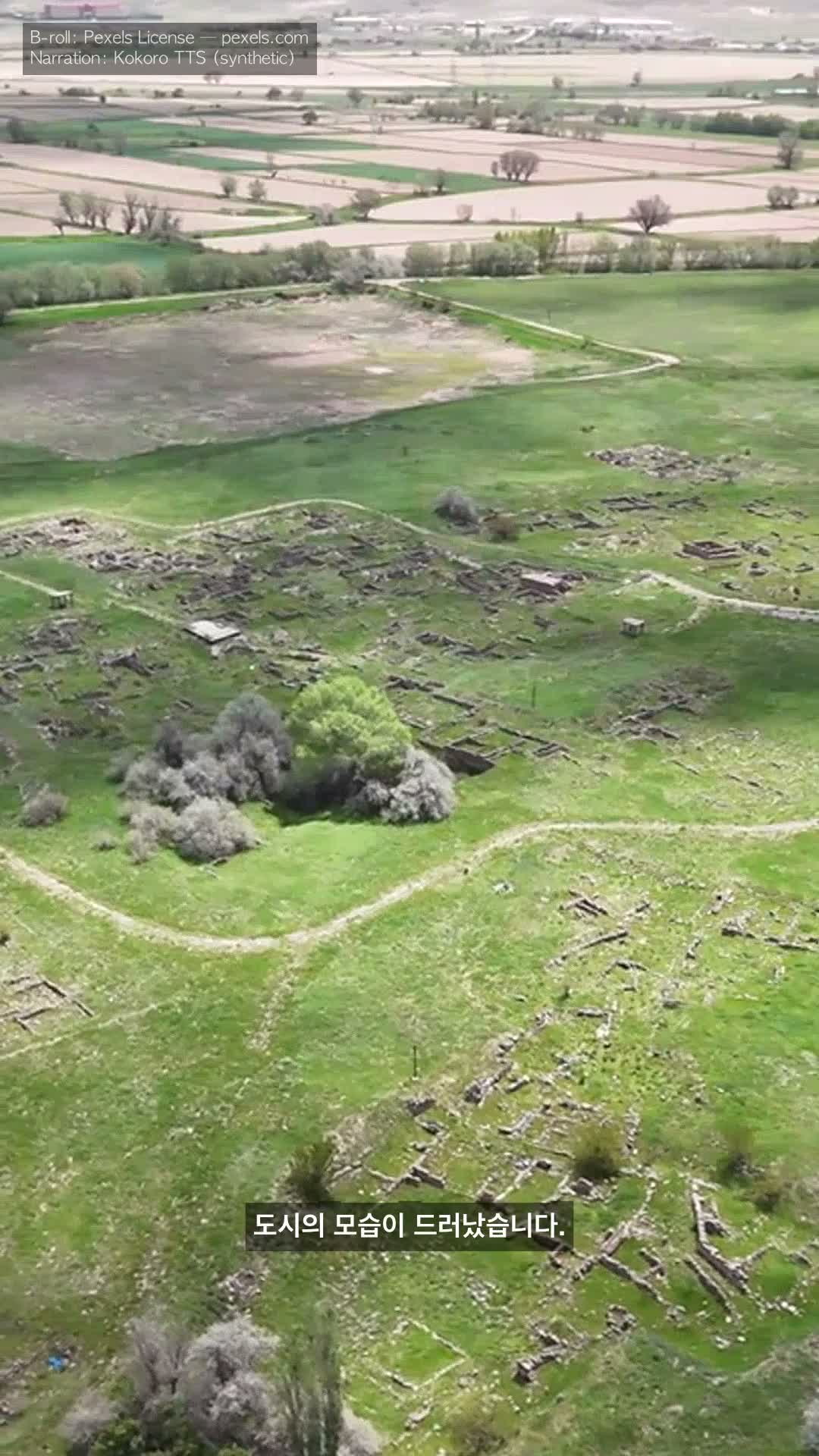 Hittites KO — Korean caption '도시의 모습이 드러났습니다.' single-line over aerial Hattusa archaeology, AppleGothic font, macOS Yuna voice