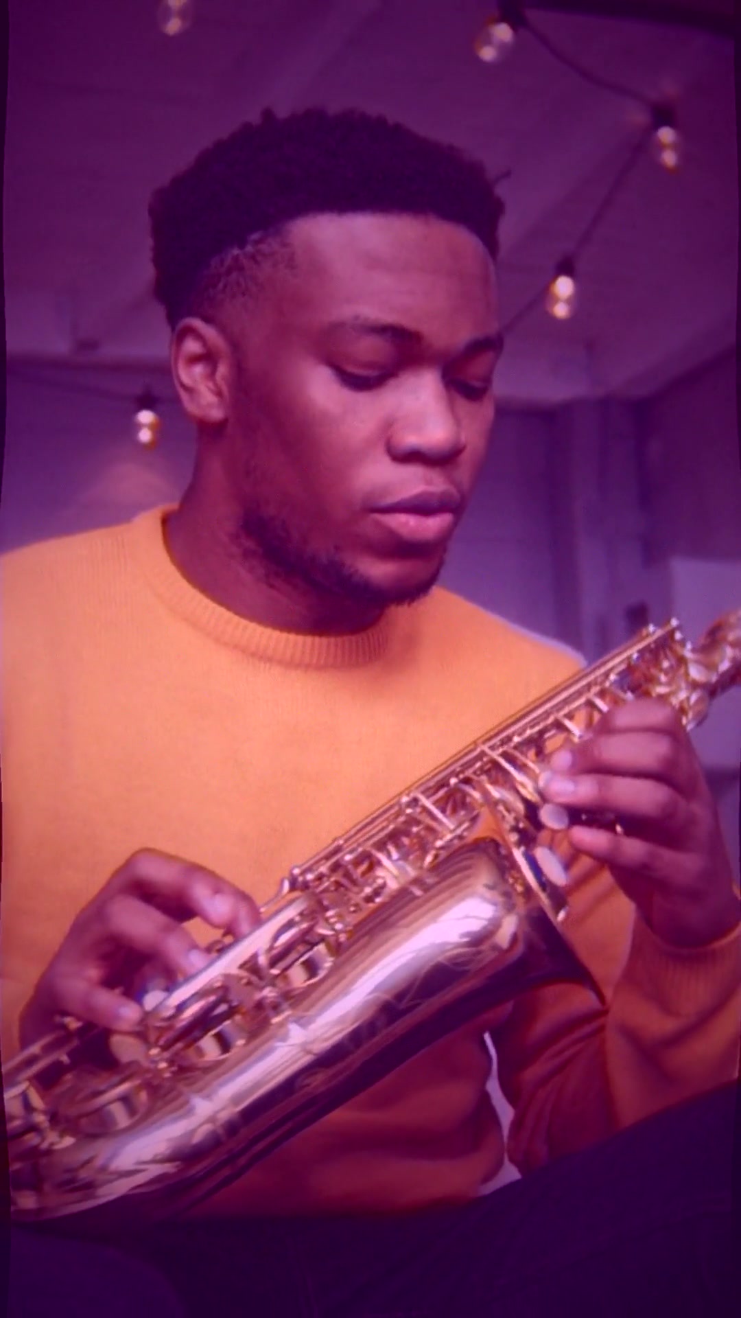 Mid-climax frame from outputs/publish/03e-velvet1-jazz-combo.mp4 — 9:16 vertical, vintage jazz interior with amber lamp, vinyl record motif, warm halation bloom around bright sources and subtle pond-surface ripple displacement across the whole frame, Pexels-licensed B-roll under a Suno-generated lo-fi jazz track