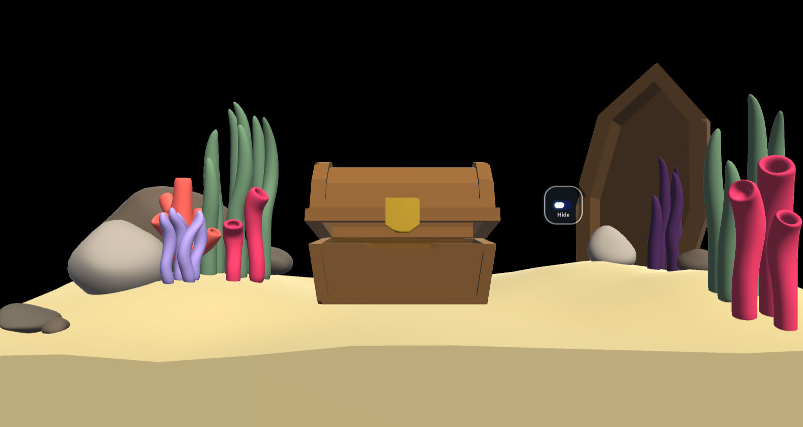 An aquarium scene that consists of sea coral, sea grass, and rocks surrounding the environment. A boat is placed into the sand in the back right corner. A treasure chest is placed in the middle of the aquarium. A hide toggle button is to the right of the treasure chest.