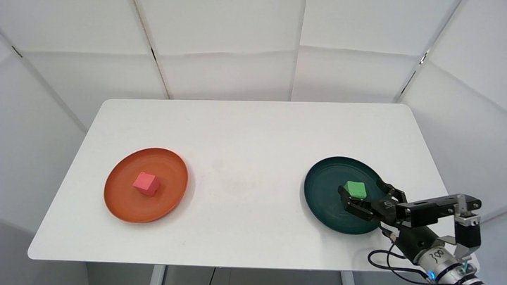 RealSource robot gripper moving a green block onto a plate in a tabletop manipulation demonstration