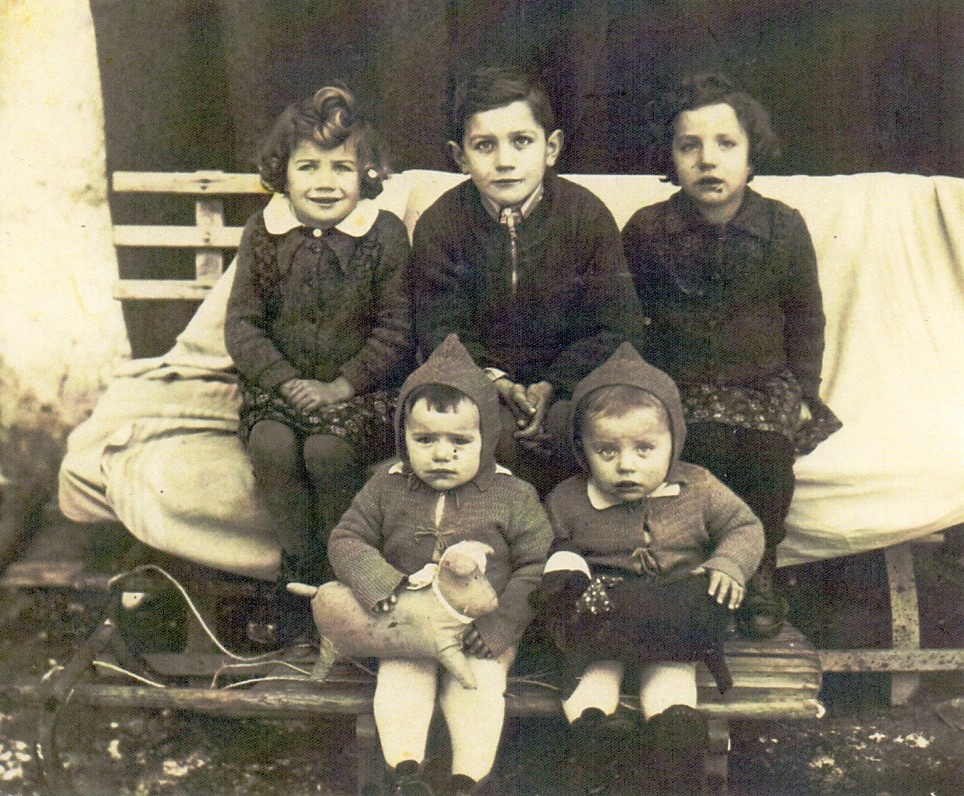 Mrzlega februarja leta 1942, v vasi Sv. Neža, osem mesecev po smrti očeta
                        Alojzija Zabreta. Na sankah sedita dvojčka Tilka in Blaž, na klopi pa Metka,
                        Ciril in Slavka.