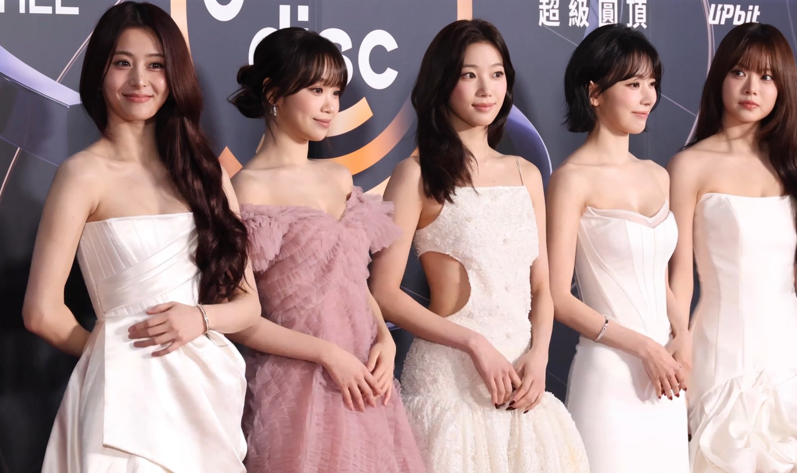 LE SSERAFIM on the red carpet at the 2026 Golden Disc Awards, all five members in white and pink gowns. Photo by TV10, CC BY 3.0, via Wikimedia Commons
