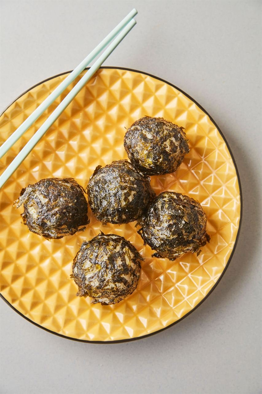 A yellow plate of seaweed-coated Korean rice balls with chopsticks resting on the rim. — ⓒ한국관광공사 포토코리아-알렉스 분도 (Korea Tourism Organization, KOGL Type 1)