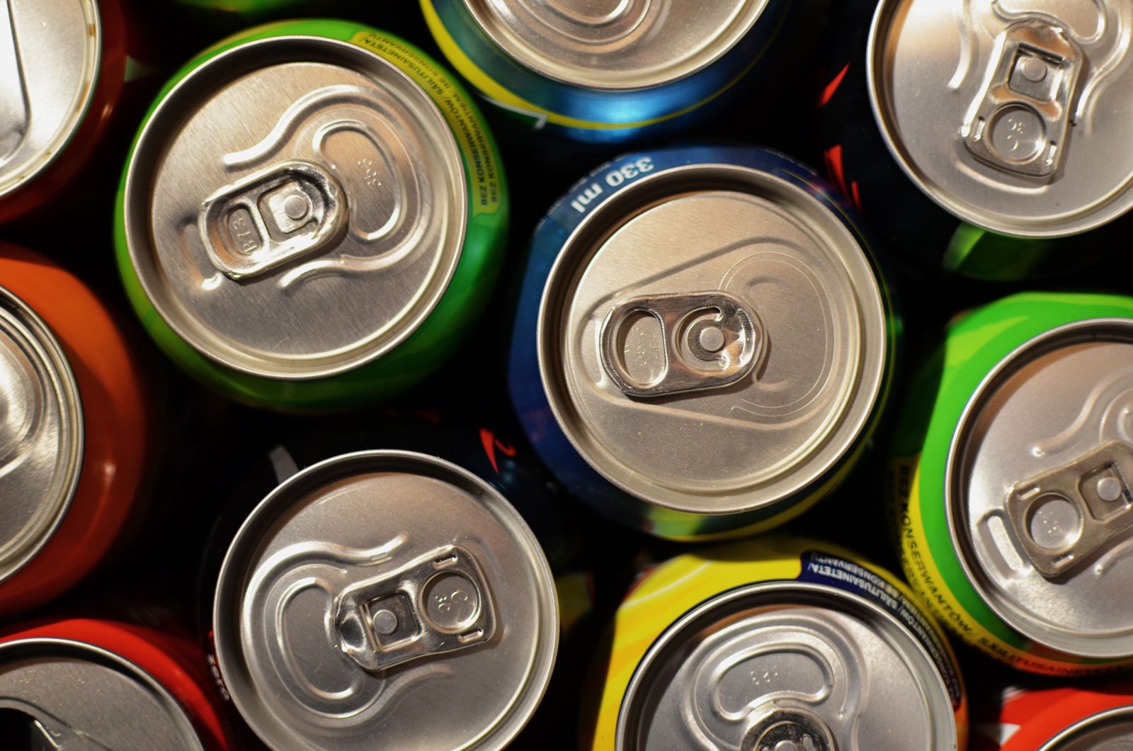 A top-down photo of colorful soft drink cans packed together, shown only as a generic example; these are not Korean brands. Photo by Breakingpic on Pexels