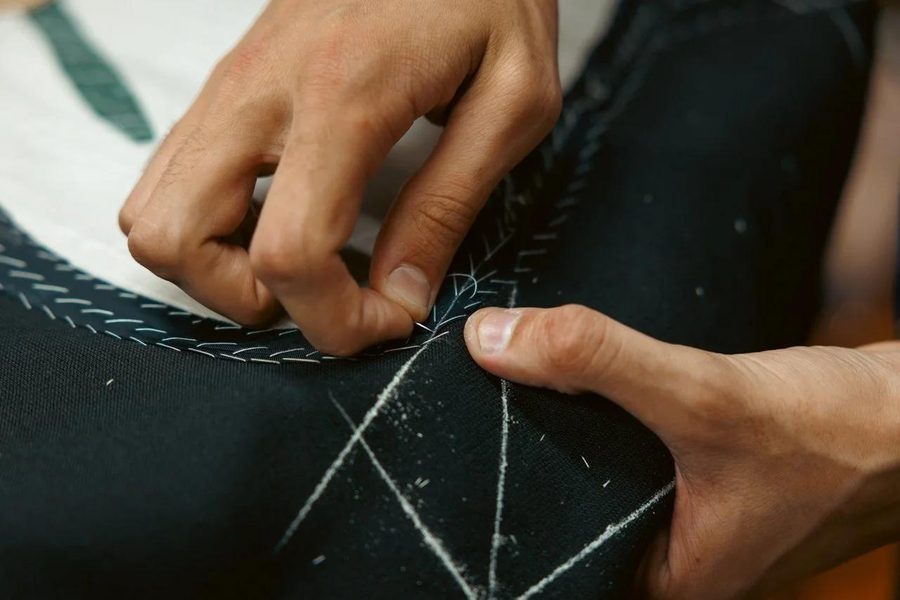Craftsman hand-finishing technical seam construction with chalk markings