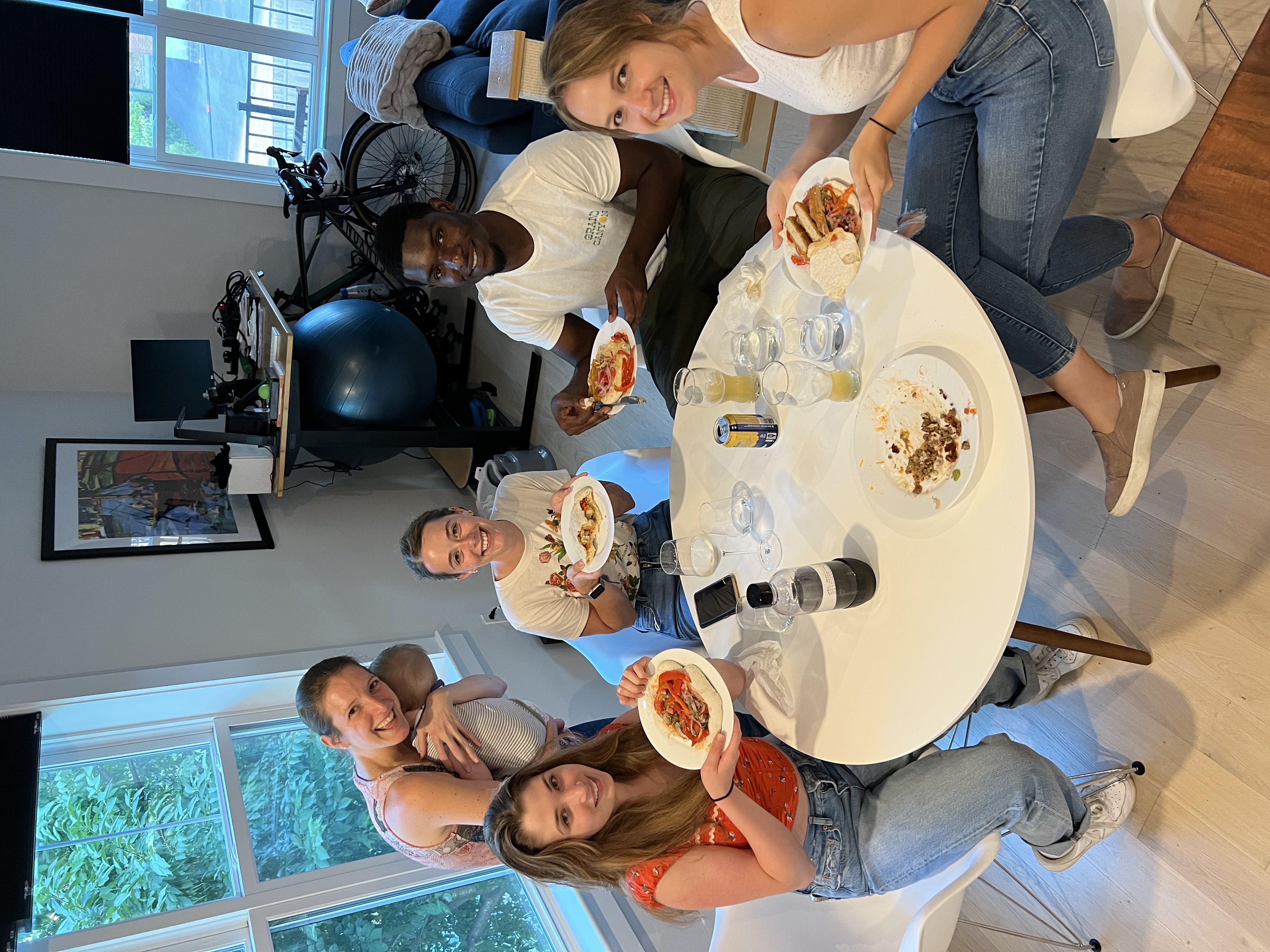 Lab members gathered around a table enjoying pizza together