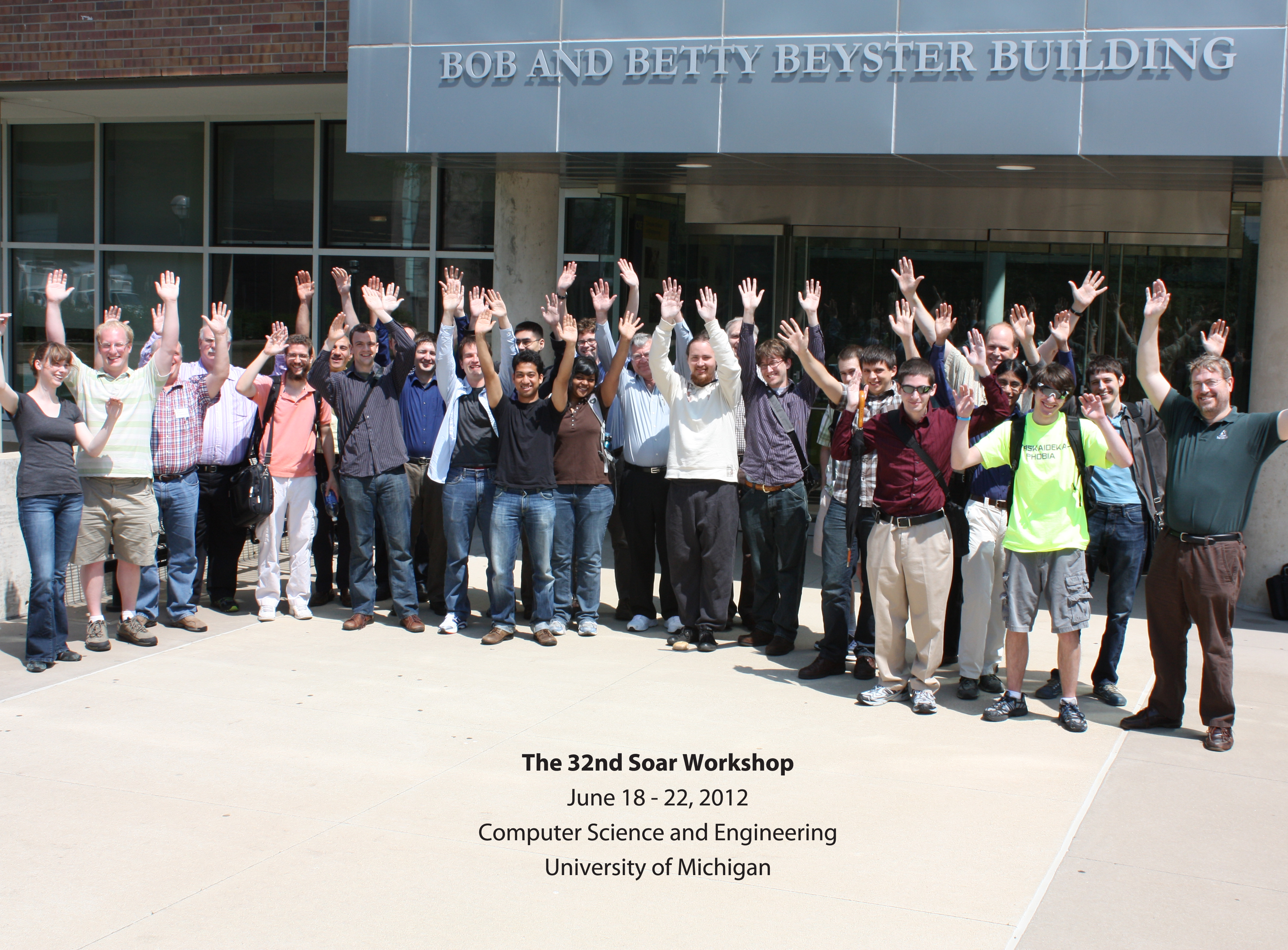 Participant group photo in front of Beyster building with arms raised (making waves), 2012