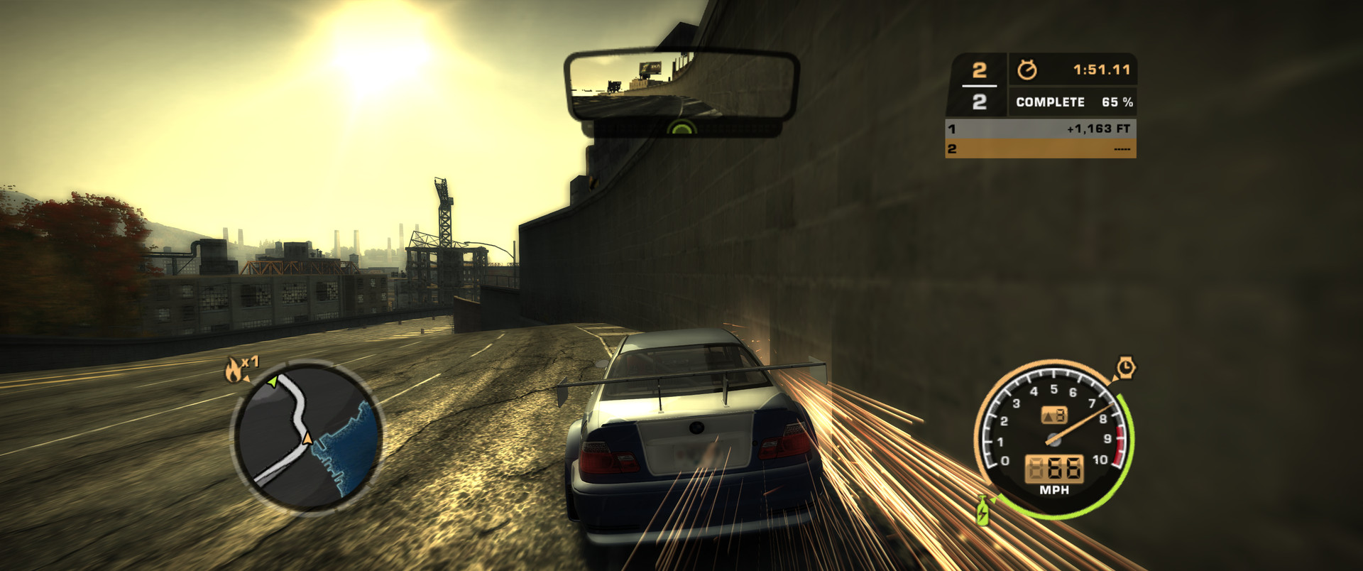Racing at 21:9 into a low sun, sparks flying off the wall, HUD and rear-view mirror visible