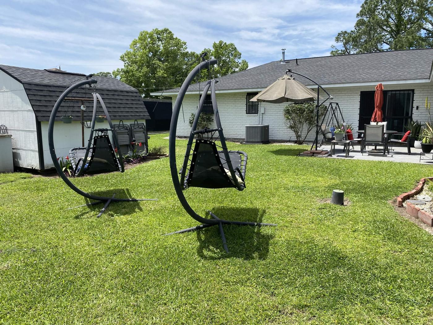 Manicured backyard with hanging chairs