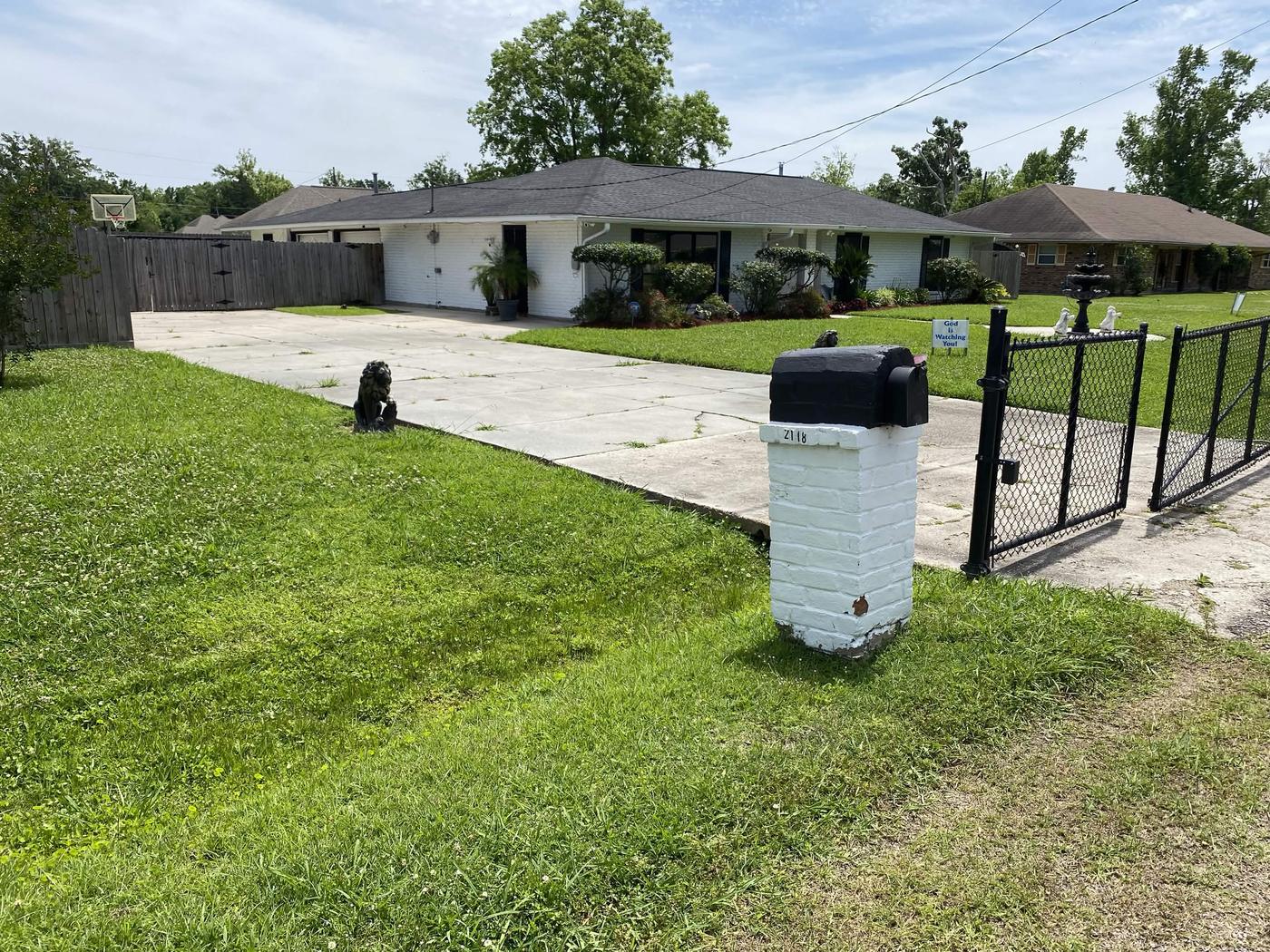 White brick home with a neatly trimmed lawn