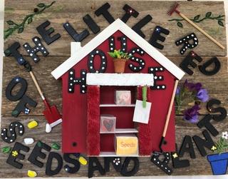 The Little Red House of Seeds and Plants sign