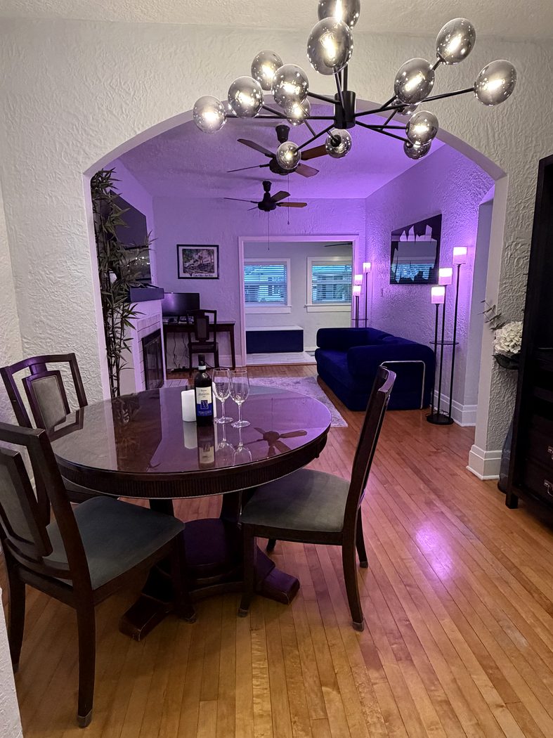 Dining room with smart lighting and living area beyond