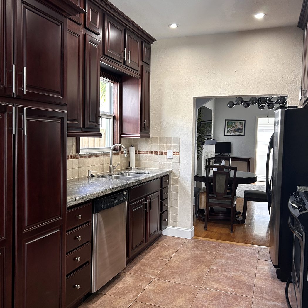 Fully equipped kitchen with dark wood cabinetry and stainless appliances